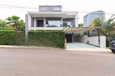 Casa em condomínio no Rio Tavares com 5 suítes, piscina e área gourmet. Sofisticação e contato com a natureza.